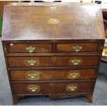 A George III oak bureau, the fall front inlaid with shell paterea, fitted interior,