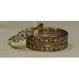 A 9ct gold eternity ring, 4.2g; an 18ct gold three stone illusion set diamond ring, 1.