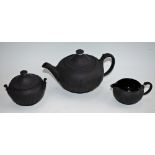 A Wedgwood three piece black basalt teapot, milk jug and sugar bowl,