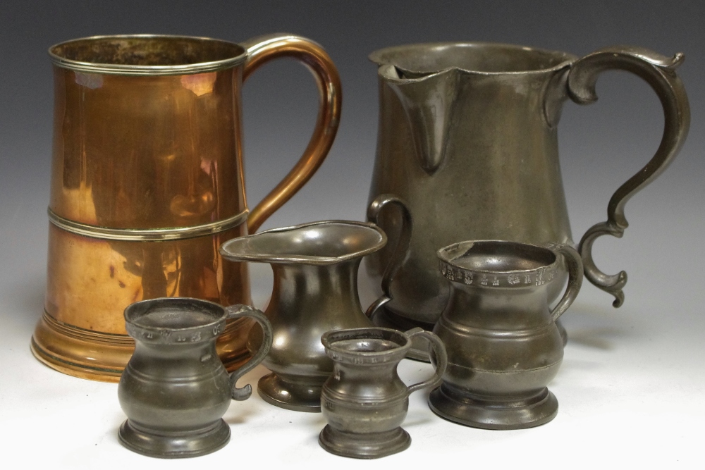 A Victorian pewter quart measuring jug; three smaller; a pewter cream jug;