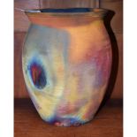 An earthenware ovoid raku vase, attributed to Willie Carter, in typical matt rainbow tones,