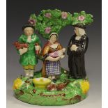 A Staffordshire figure group, The Tithe Pig group, modelled with parson and a couple,