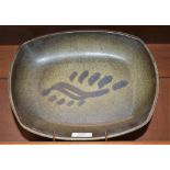 A Sam Haile stoneware rounded rectangular dish, resting on four peg feet,