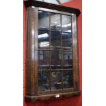 An early 20th century oak corner display cabinet,