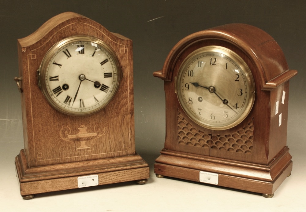 An Edwardian oak inlaid arched mantel clock, outlined with boxwood stringing with central urn motif,