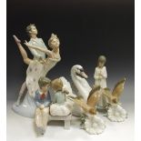 A Lladro model, as a swan; a Lladro figure, of bird hovering over a flower; another,