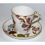 A Worcester cup and saucer, painted with flowers and butterflies picked out in gilt,