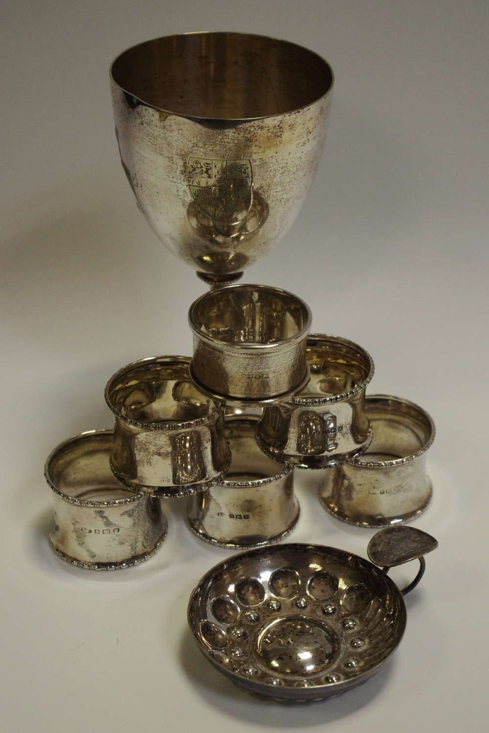 A set of five silver napkin rings; another; plated goblet;