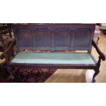 An 18th century oak settle, four fielded panels to back, open arms, cabriole forelegs, pad feet,