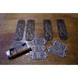 A reproduction cast metal toilet roll holder; five reproduction cast metal signs;