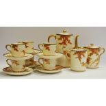 A Japanese Satsuma six-setting coffee set, painted with leafy trees in autumnal tones,