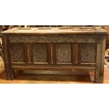 An oak blanket box, four panels to top, lunette carved frieze, four carved panels to front,