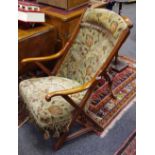 An early 20th century mahogany X frame easy chair, turned finials, reeded uprights, open arms,