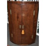 A George III mahogany bow front corner cupboard,