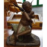 A reproduction bronze figure, as a seated cherub, with wings spread, on rocky base,