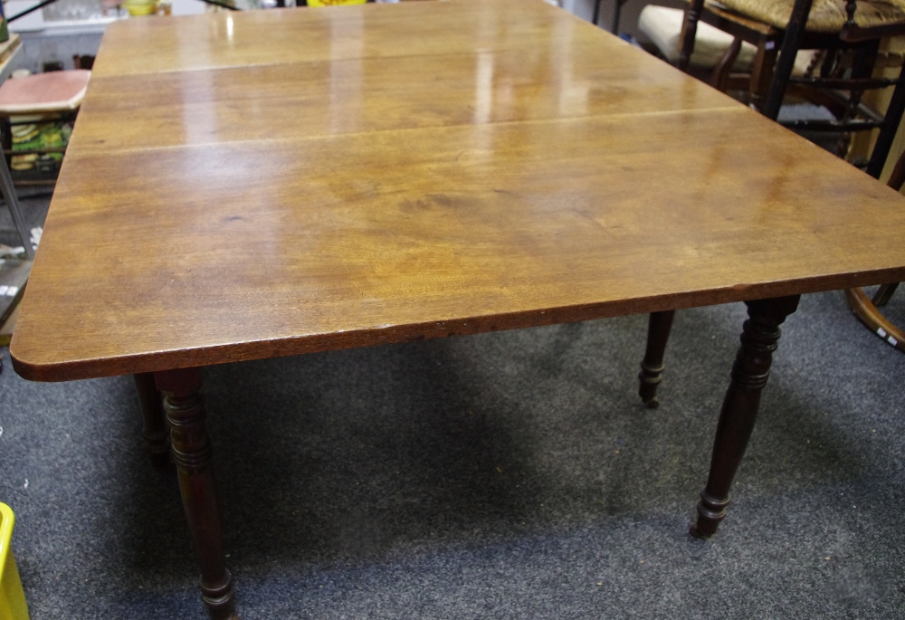 An early 19th century drop leaf dining table, turned legs, ceramic casters,
