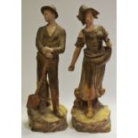 A pair of Austrian earthenware figures, Farmer and wife, signed J. School, 33cm c.