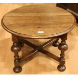 An early 20th century oak low occasional table, circular moulded top, bold turned supports,