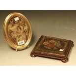 A 19th century needlework kettle stand; an oval needlework picture, depicting a girl with a cat,