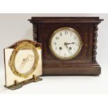 A 1930's oak mantel clock, rectangular case with barley twist supports, white enamel dial,
