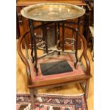 A Chinese hardwood folding centre table, the circular brass top profusely engraved with characters,