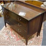 An Edwardian chest of three long graduated drawers, tapering square legs,