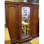 A Victorian break front mahogany triple wardrobe, central mirrored door flanked by panelled doors,