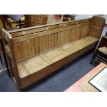 A Church pew, panelled ends, five number seats with hinged covers to seat box,