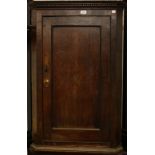 A George III oak wall hanging corner cupboard,