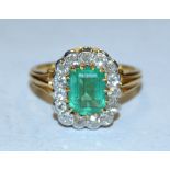 An emerald and diamond ring, central rectangular cushion cut vibrant green emerald, approx 0.