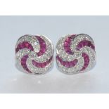 A pair of diamond and ruby quarter lobed vortex cluster earrings,