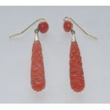 A pair of tubular carved drop coral earrings, silver coloured metal fittings, hook pillars,