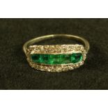 An emerald and diamond cluster ring, central crest of five old irregular and cushion cut emeralds,
