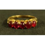 A ruby quintet ring, linear set with five pinky red cabochon rubies,