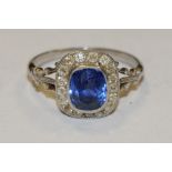 A 'Burmese' sapphire and diamond cluster ring, central cushion cut vibrant blue sapphire, approx 7.