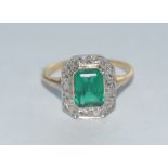 A synthetic emerald and diamond cluster ring, central octagonal vibrant green synthetic emerald,