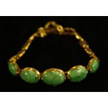 A jadite five panel cabochon bracelet, five graduated oval cabochon panels of natural green jadeite,