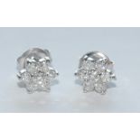 A pair of diamond floral cluster earrings, each encrusted with seven round brilliant cut diamonds,