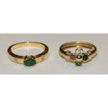 An 18ct gold emerald ring, centrally set oval emerald and two round diamonds set into the shoulders,