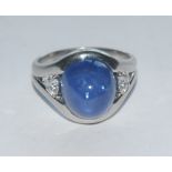 A cabochon sapphire and diamond ring, central domed blue sapphire, measuring approx 10.32mm x 11.