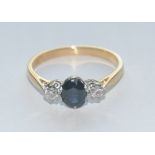 A sapphire and diamond trilogy ring, central oval deep blue sapphire approx 0.
