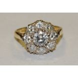 A diamond cluster ring, central round brilliant cut diamond approx 0.