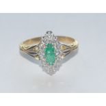 An emerald and diamond cluster ring, central navette cut emerald approx 0.