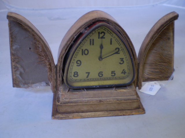 A TRIANGULAR BEDSIDE CLOCK IN LEATHER CASE