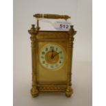 A BRASS CARRIAGE TIMEPIECE WITH ARABIC NUMERALS ON ENAMELLED CHAPTER RING,