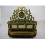 A FRENCH MANTLE CLOCK OF CUT BRASS STANDING ON OVAL? MARBLE FILLED BRASS BASE OVER WOOD BASE,