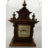 A HARDWOOD MANTLE CLOCK WITH PODGER TOP 2 CARVED COLOMNS, GILDED DIAL WITH ROMAN NUMERALS,