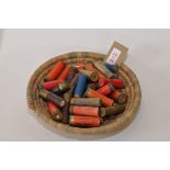 AN ASSORTMENT OF SHOTGUN CARTRIDGES, MOSTLY VINTAGE, SOME SPENT, IN A BASKET.