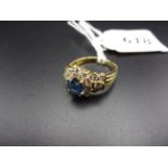AN 18K GOLD (750) CLUSTER RING SAPPHIRE? SURROUNDED BY DIAMONDS 5.