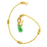 Yellow gold bracelet and jade charm